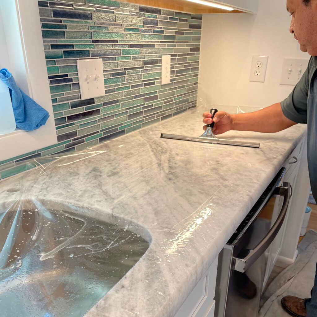 Stone care expert sealing freshly cleaned and polished countertop
